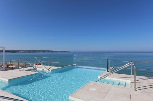 a swimming pool with the ocean in the background at Iberostar Bahía de Palma - Adults Only in Playa de Palma