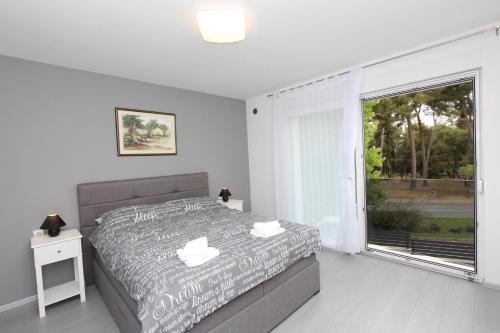 a bedroom with a bed and a large window at Apartment Karlo 2 in Rovinj