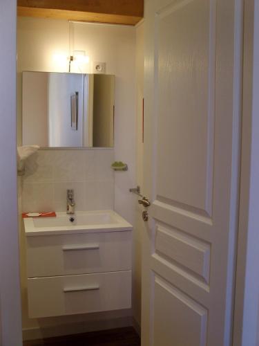 a bathroom with a sink and a mirror and a door at Les Chambres de Jeannette in Marseille