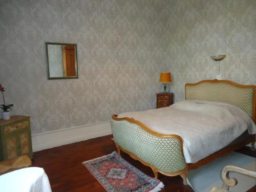 a bedroom with a bed and a mirror on the wall at Maison de maître en baie de Somme in Favières