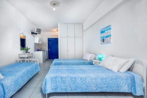 duas camas num quarto com azul e branco em Xenios Loutra Village Arsinoi Studios em Agia Paraskevi