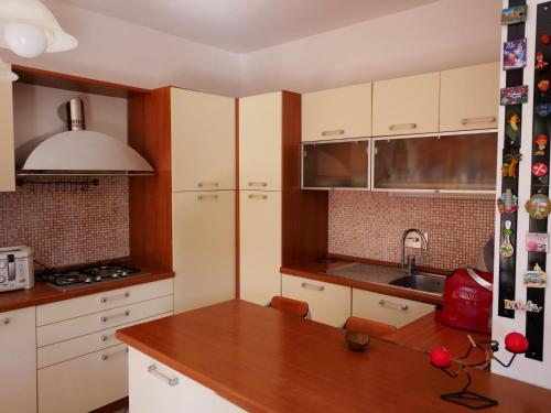 eine Küche mit weißen Schränken und einer hölzernen Arbeitsplatte in der Unterkunft la casa di sandra in Pugnano