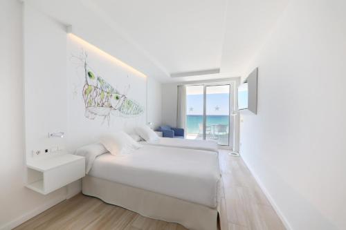 a white bedroom with a bed and a sink and a window at Iberostar Bahía de Palma - Adults Only in Playa de Palma