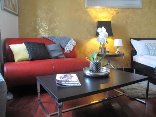 a living room with a red couch and a coffee table at Studio apartment Sofia in Poreč