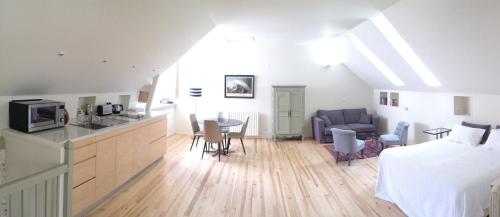 a kitchen and a living room with a bed and a table at Clos Mirabel Manor - Holiday rental in Jurançon