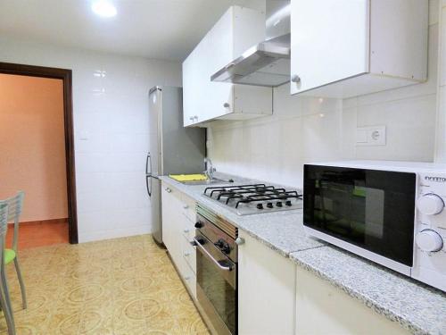 a kitchen with a stove and a microwave at LOVE ALICANTE in Alicante