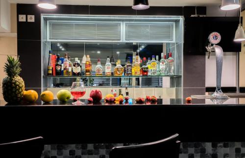 a bar with drinks and fruit on a counter at Denise Beach Hotel in Laganas