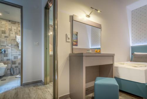 a bathroom with a sink and a mirror at Denise Beach Hotel in Laganas