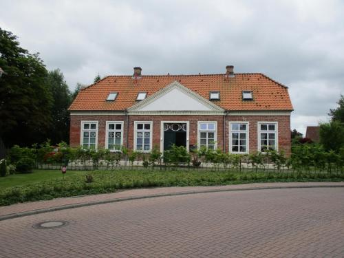 a large brick house with a red roof at Haus am Herrenwall in Esens