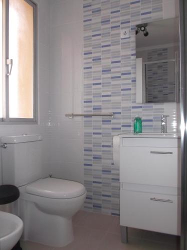 biała łazienka z toaletą i umywalką w obiekcie O Cabalo Verde w mieście Palas de Rei 