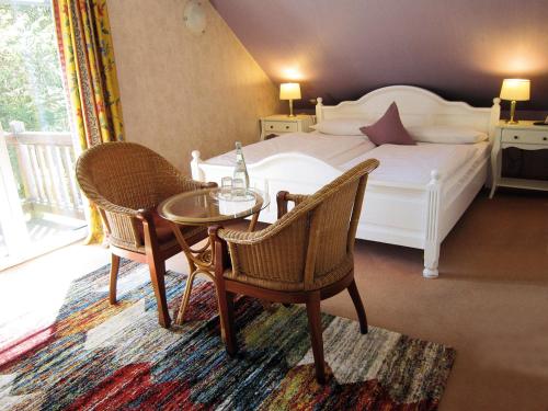 a bedroom with a bed and a table and chairs at Hotel Klaus Störtebeker in Ralswiek