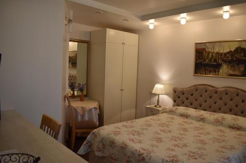 a bedroom with a bed and a table with a lamp at Saulės Krantas in Palanga