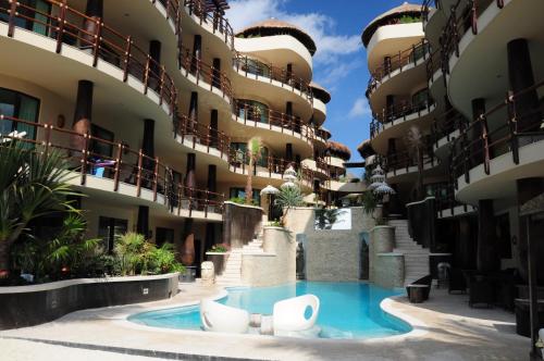 a large swimming pool with a balcony overlooking a city at El Taj Oceanfront and Beachside Condo Hotel in Playa del Carmen