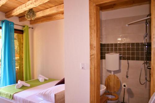 - une chambre avec une salle de bains pourvue d'une douche et un lit dans l'établissement Boutique B&B Agroturizam Sv. Juraj, à Krk