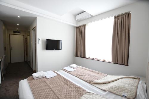a bedroom with two beds and a flat screen tv at Atrijum Apartments and Rooms in Kladovo