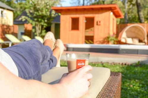 a person sitting at a table with a glass of coffee at Hotel Lukács Superior in Kazincbarcika