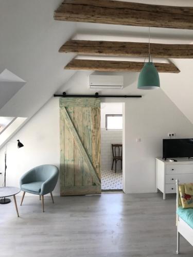 an open living room with a sliding barn door at Fügekert - Bed&Wine in Zánka
