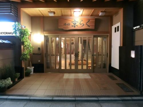 una porta d'ingresso di un edificio con un cartello sopra di Ryokan Kyoraku a Kyoto