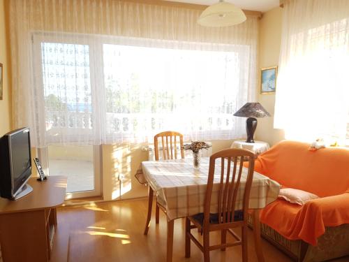 a living room with a table and chairs and a television at Trakata Villa Apartments in Varna City