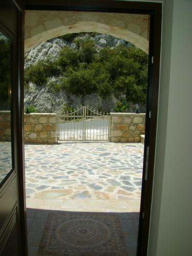 an open door to a patio with a stone wall at Starlit Villa in Kathikas