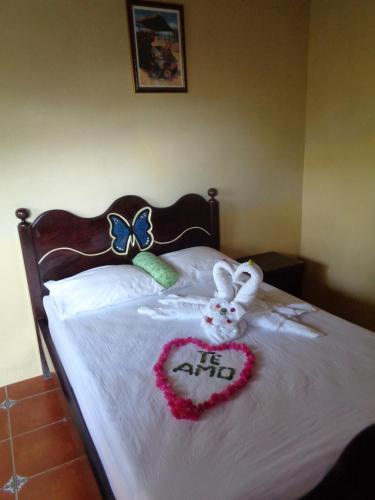 a bed with two stuffed animals and a heart on it at Ecolodge Blue Morpho in Cárdenas