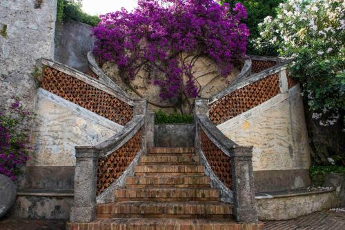 a set of stairs with a bunch of purple flowers at La Valle Delle Najadi in Vietri sul Mare