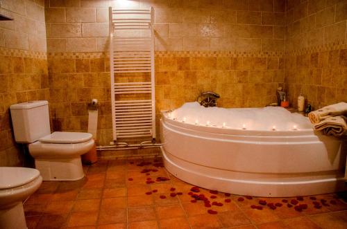 La salle de bains est pourvue d'une baignoire blanche et de toilettes. dans l'établissement Alojamiento Rural Pelijas, à Fontanar