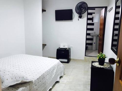 a bedroom with a white bed and a mirror at Hotel Mirador de Santa Bárbara in Socorro
