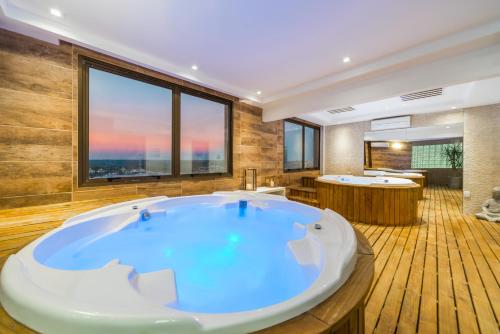 Hotel Laghetto Bento في بينتو جونكالفيس: حمام كبير مع حوض كبير ومغسلتين