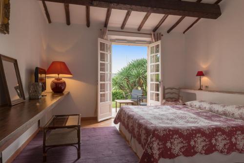 - une chambre avec un lit et une porte ouverte dans l'établissement Saint-Vincent, à Saint-Tropez