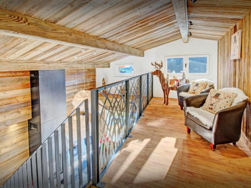 a hallway with two chairs and a staircase in a house at Chalet Alyssum - OVO Network in Le Grand-Bornand