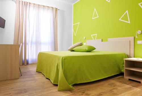a green bedroom with a bed with a green blanket at Ai Gradini Affittacamere in Castellammare del Golfo
