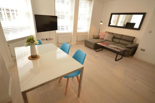 a living room with a table and a couch at St Anne's Court by Indigo Flats in London