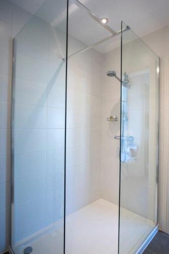 a shower with a glass door in a bathroom at Baie Mooar House, Boutique B&B in Ramsey