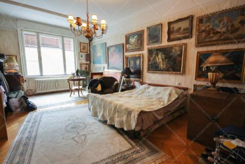 ein Schlafzimmer mit einem großen Bett und Gemälden an den Wänden in der Unterkunft Keleti Károly apartmant in Budapest