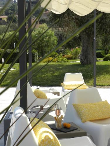 a patio with white chairs and an umbrella at ReBi Village in Imperia
