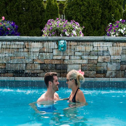 a man and a woman in a swimming pool at Pillar and Post Inn & Spa in Niagara on the Lake