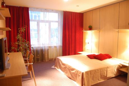 a bedroom with a bed and a window with red curtains at Cafe Hotel Rudzons in Madona