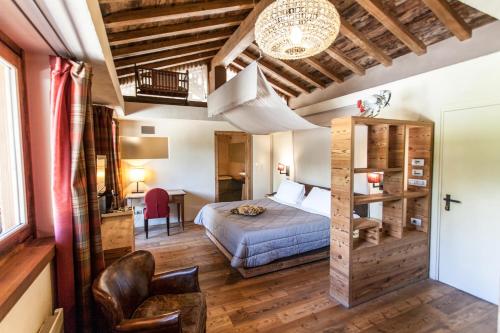 um quarto com uma cama e uma cadeira num quarto em Chalet Eden Eco Hotel, Restaurant & Wellness em La Thuile