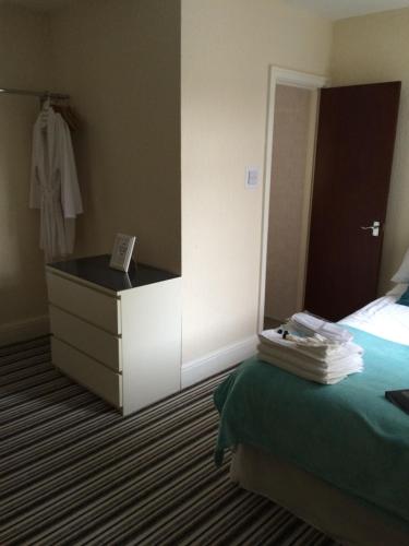 a hotel room with a bed and a dresser at The Oxfordshire in Blackpool