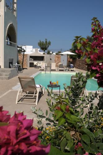 a swimming pool with a chair and some flowers at Astarte Sea Villas in Dhiakofti