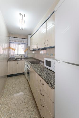 a kitchen with white cabinets and granite counter tops at Prado in Peniscola