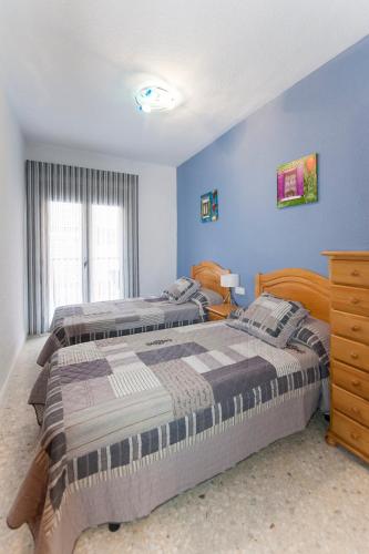 two beds in a bedroom with blue walls at Prado in Peniscola