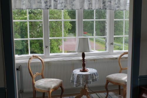 two chairs and a lamp in front of a window at Trunna Vandrarhem & Konferens in Orsa