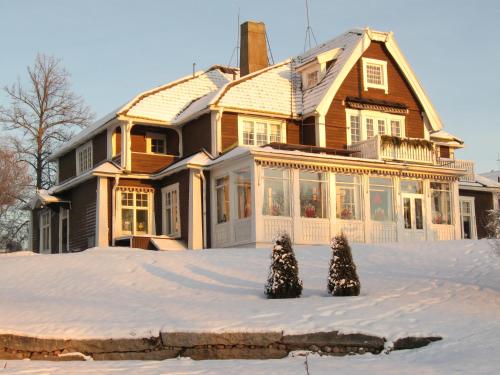 a house with two christmas trees in the snow at Trunna Vandrarhem & Konferens in Orsa