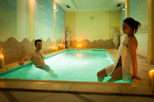 a man and a woman in a swimming pool at Sartori's Hotel in Trento