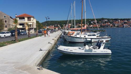 two boats are docked at a dock in the water at Apartments Valentina Tisno in Tisno