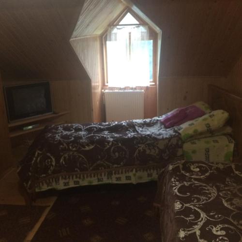 a small bedroom with two beds and a window at Krasa Karpat in Snidavka