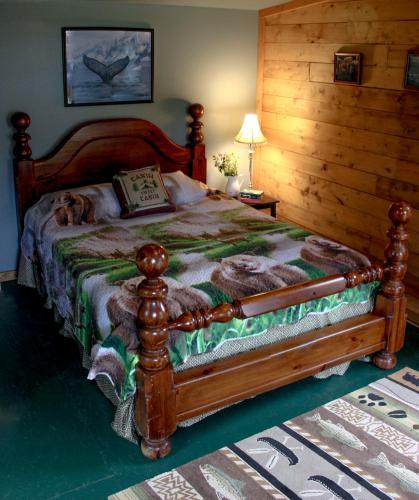 a bedroom with a bed with a dog laying on it at Whispering Winds Retreat B&B in Ninilchik