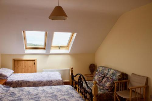 1 dormitorio con 2 camas, 1 silla y 2 ventanas en Cuas a' Gamhna, en Isla de Valentia